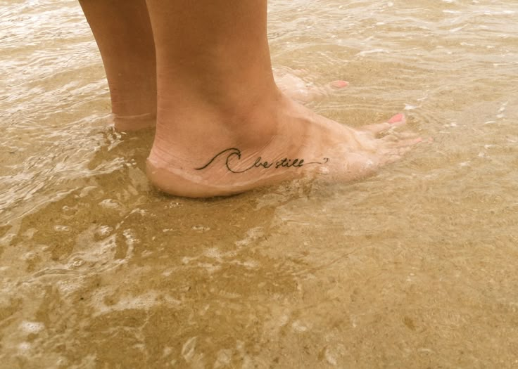 a woman's foot in the water with her name written on it