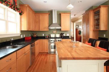 a kitchen with wooden cabinets and stainless steel appliances, along with an island countertop