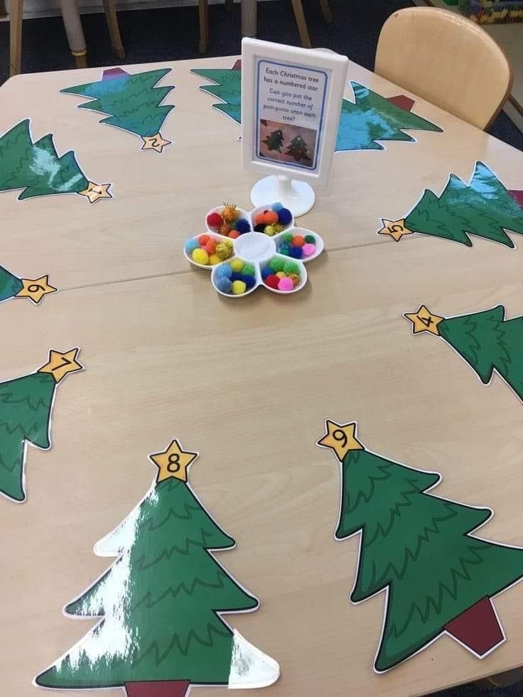 a wooden table with christmas trees painted on it and some candies in the middle