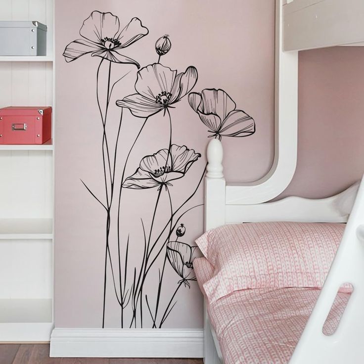 a bedroom with pink walls and flowers painted on the wall