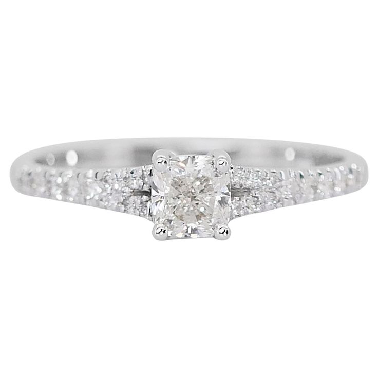 a white gold ring with an oval cut diamond in the center and pave set shoulders