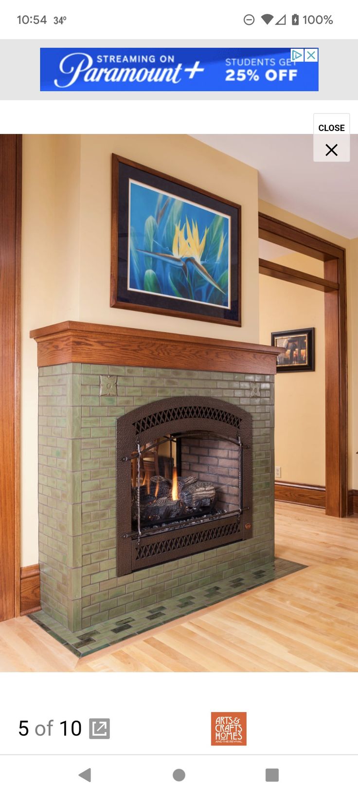 an image of a fireplace in the middle of a living room with wood flooring