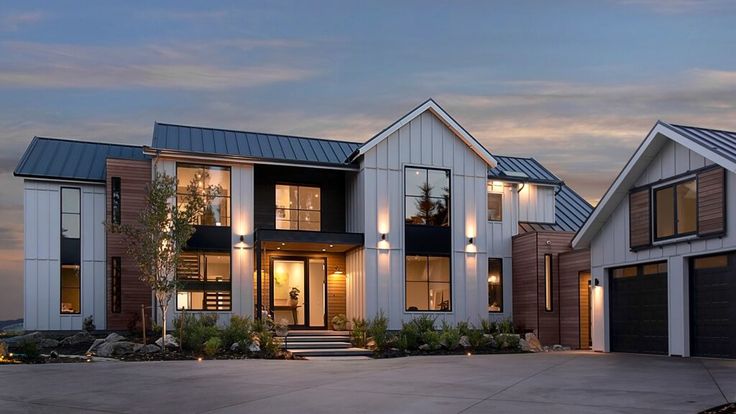 two story house with white siding and dark windows at dusk in front of an overcast sky