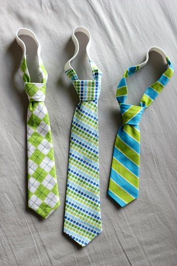 three ties are laid out on a bed