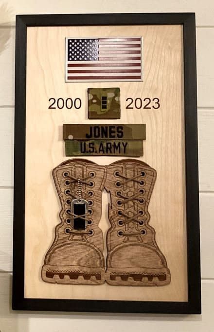 a wooden plaque with an army boot and flag on it