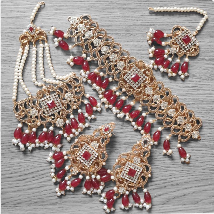 introducing our new collection for up coming wedding and festive season . Here is our new Indian necklace set for the season of weddings and festivals . This set is specially made as bridal as it has many accessories that suits to bridal and occasional wearing and the best part is that its    handmade. This gold and red bridal set are commonly worn in Asian , Pakistani , Indian weddings and festivals. This necklace comes with a chocker necklace , earring tikka and jhumar passa .  please feel free to ask any question , we will  be happy to help you out  HAPPY BUY Red Temple Jewelry For Eid, Festive Bridal Sets With Stone Work For Eid, Festive Red Jhumkas With Zari Work, Red Tikka For Eid Festival, Red Sets With Stone Work For Diwali, Red Stone Work Sets For Diwali, Red Tikka For Eid Festive Occasion, Red Festive Tikka For Eid, Red Jewelry With Stone Work For Eid