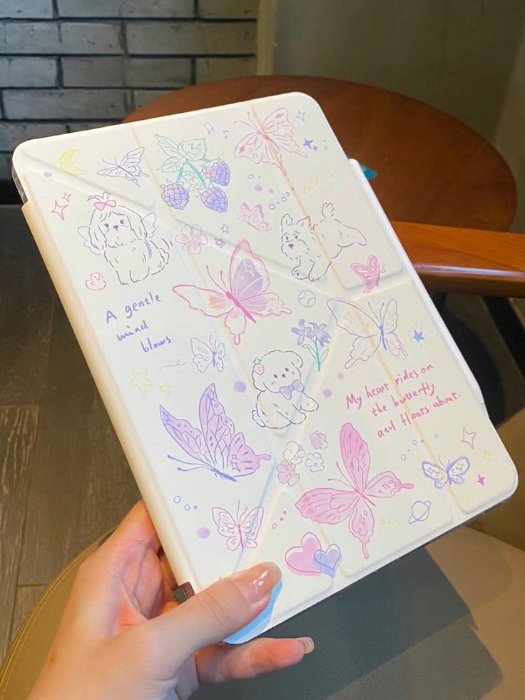 a person holding a notebook with drawings on it