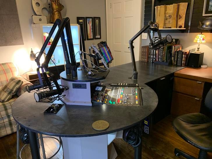 a desk with some electronics on it in a home office area next to a couch