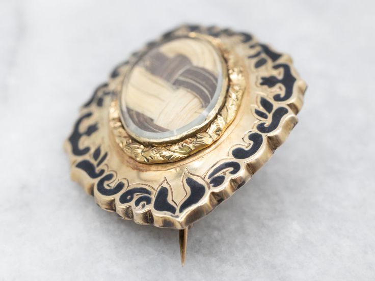 This Victorian brooch is a classic of the era, a mourning pin. Extremely hard to find in this excellent condition, this piece is gold, with the original black enamel still crisp and in near-perfect condition. The center of the pin is glass, with a woven web of blond and brunette hair laid beneath, this is an exceptional example of highly collectible Victorian hair jewelry!Love this piece, but want to make it more versatile? We here at Market Square Jewelers, along with our master metalsmiths can Antique Style Enamel Brooch Pin For Formal Wear, Victorian Style Formal Enamel Brooch Pin, Blond And Brunette Hair, Victorian Hair Jewelry, Victorian Hair, Victorian Brooch, Victorian Hairstyles, Market Square, Hair Laid