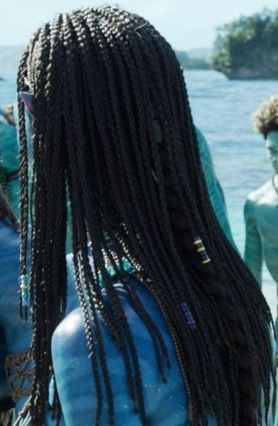 the back of a woman's head with dreadlocks standing in front of other people