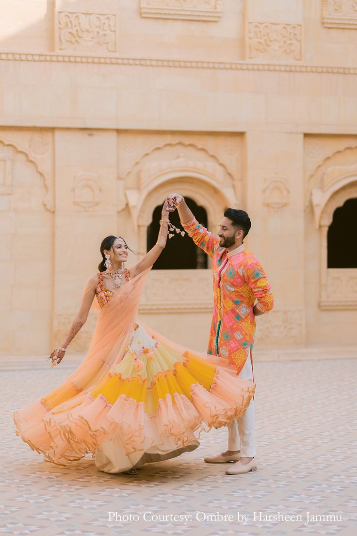 a man and woman dancing in front of a building