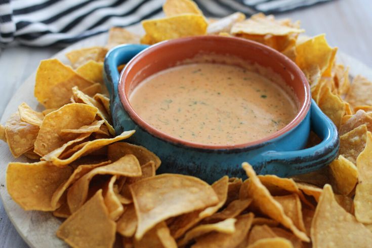 a bowl of dip surrounded by tortilla chips