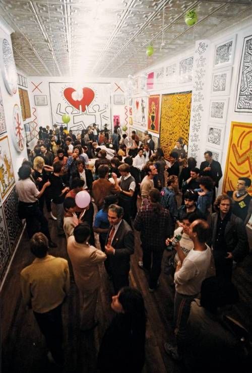 a large group of people standing in a room with paintings on the walls and ceiling