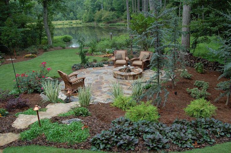 an outdoor patio and fire pit surrounded by trees