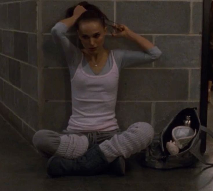 a young woman sitting on the floor with her hair combed