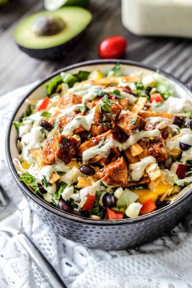 a salad in a bowl with dressing on top