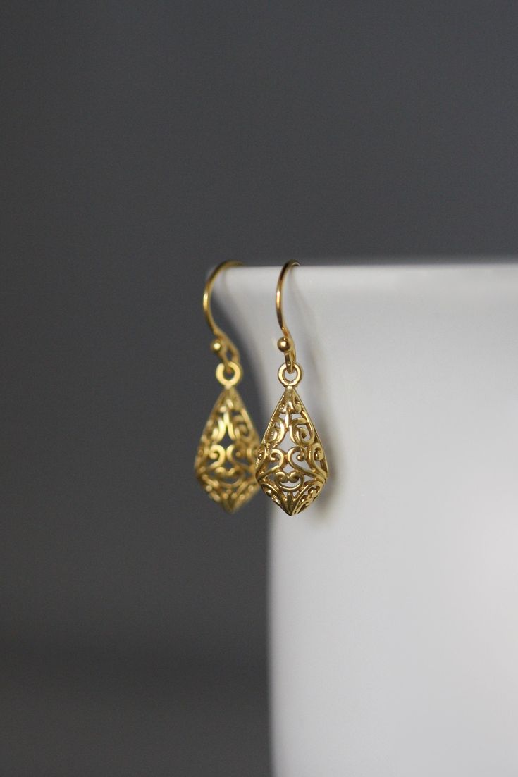 "24k matte gold vermeil filigree charms dangle from 18k gold vermeil balled earwires. Wear these elegant earrings everyday as they complete any outfit. Gold filigree charms: 9x19mm Total length of earrings: 1 1/8\" All gold is gold vermeil. This earrings are available in bright silver... www.etsy.com/listing/630528036/silver-filigree-earrings These earrings are also available in oxidized silver... www.etsy.com/listing/688867970/silver-filigree-earrings As the owner, maker, designer, and curator Gold Plated Filigree Teardrop Jewelry, Teardrop-shaped Gold Plated Filigree Jewelry, Gold Sterling Silver Teardrop Earrings For Wedding, Gold Teardrop Sterling Silver Earrings For Wedding, Delicate Gold Hypoallergenic Earrings, Delicate Hypoallergenic Gold Earrings, Dainty Gold Hypoallergenic Plug Earrings, Gold Plated Filigree Dangle Jewelry, Gold Drop Pierced Jewelry