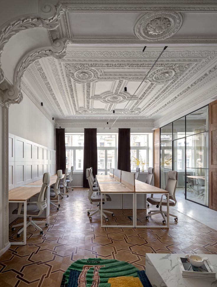 an office with many desks and chairs in the center, along with a rug on the floor