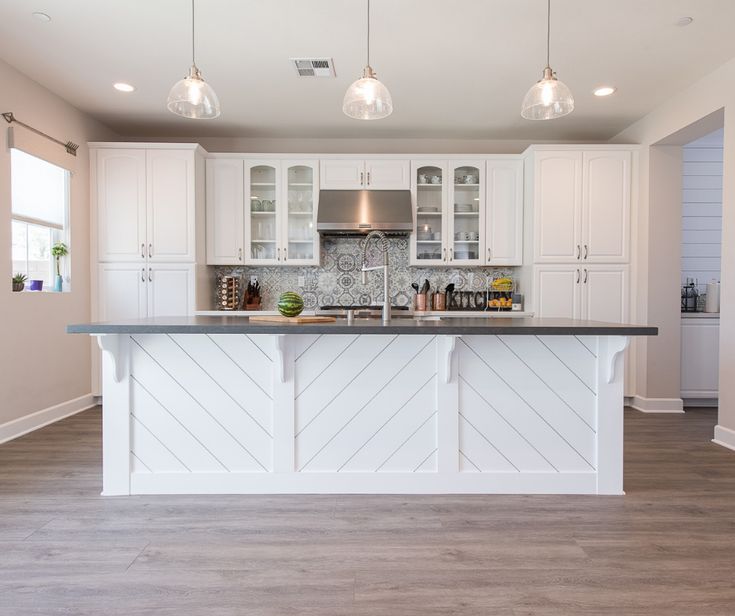 a large kitchen with white cabinets and stainless steel refrigerator freezer next to an island