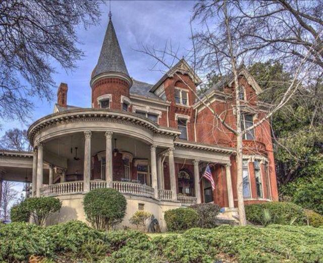 an old red brick house with a large tower on the top floor and two stories