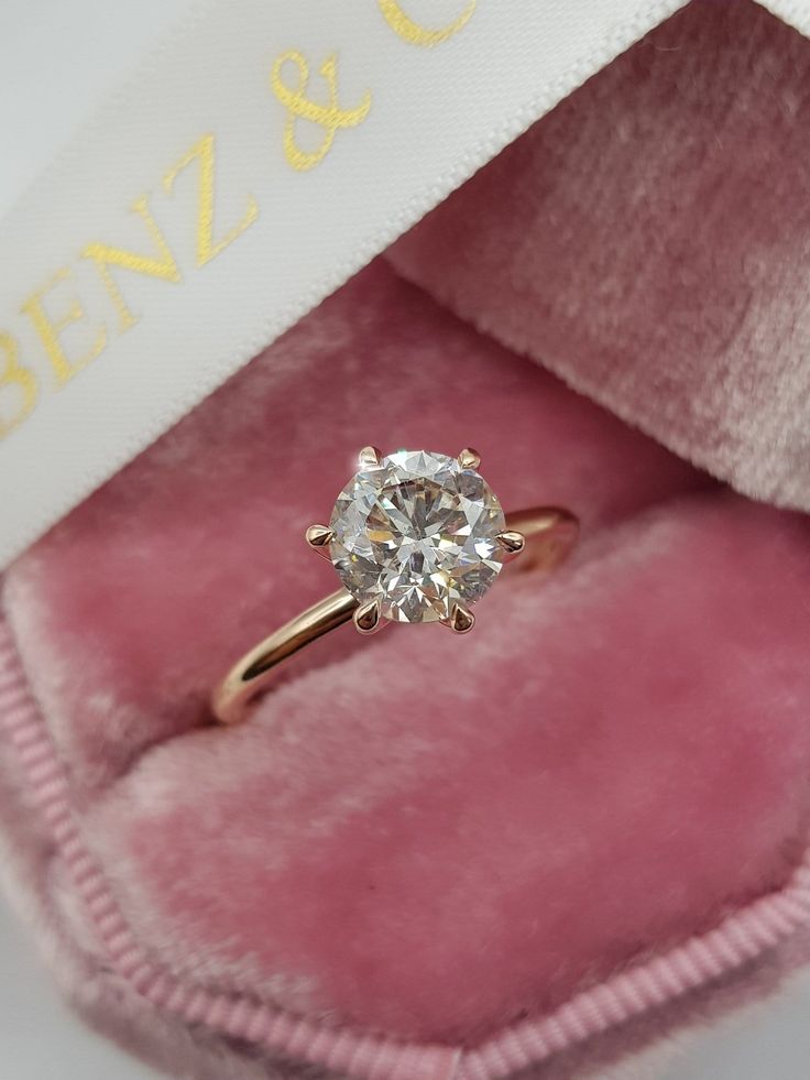 an engagement ring in a pink velvet box