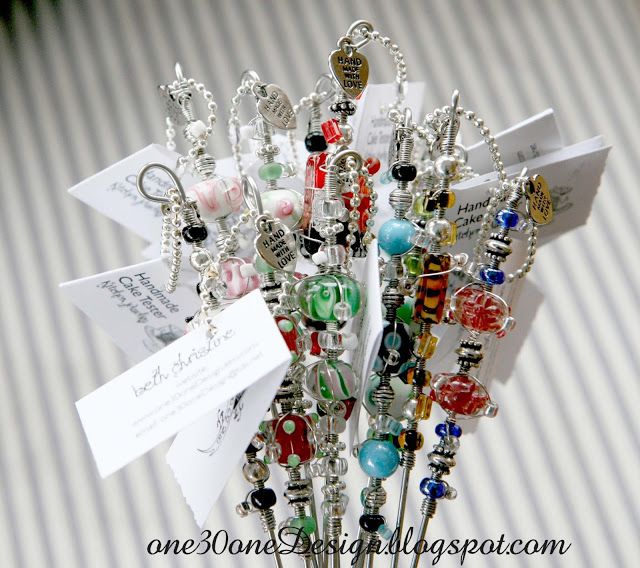 a bunch of different colored beads and charms on a table with name tags attached to them