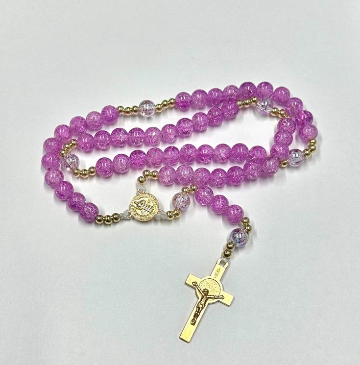 Beautiful crackled beaded rosary. Perfect gift for ourselves, birthdays, first communion, confirmation, baptism, or for that very special person. ** Crackled beads: 8mm ** Gold color spacers: 5mm ** Size: 14.5 in. ** St. Benedict medal ** Metal crucifix Pink Healing Rosary With 8mm Beads, Healing Rosary With Miraculous Medal And Round Beads, Healing Rosary With Miraculous Medal, Purple Rosary With 8mm Round Beads, Purple Rosary With 8mm Beads, St Benedict Medal, Beaded Rosary, Benedict Medal, St Benedict