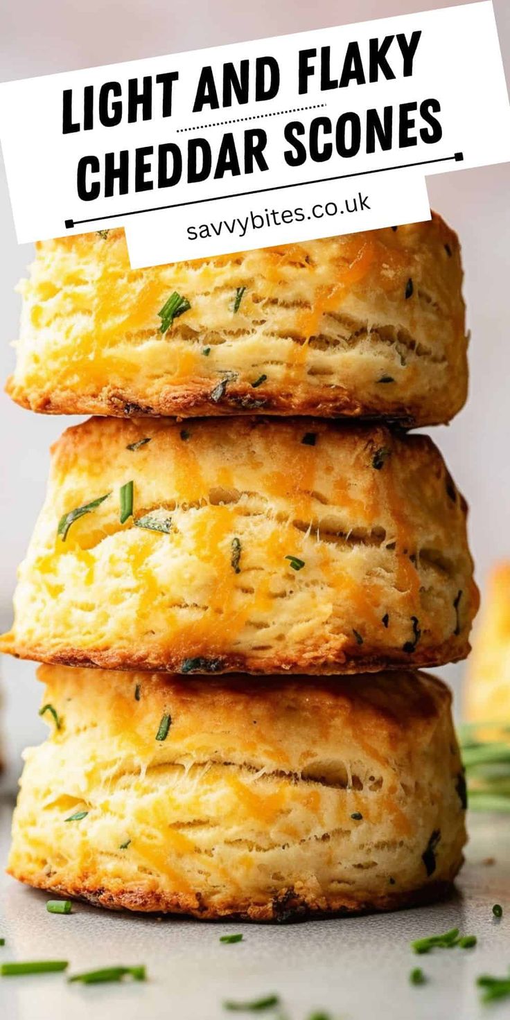 three cheddar scones stacked on top of each other with text overlay that reads light and flaky cheddar scones