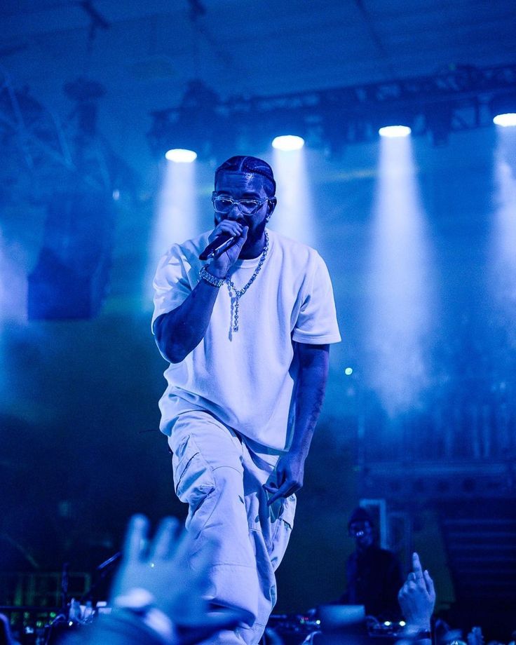 a man standing on top of a stage holding a microphone in front of his face