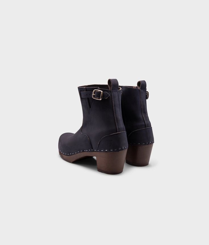 Our Manhattan boots exude confidence and professionalism, inspired by New York City and its iconic fashion scene. With its sleek design and versatile colorway, they effortlessly complement any outfit – from chic dresses to casual denim. Clog measurements:Heel height: 2 5/8” (6.5 cm)Toe height: 1 1/2″ (3.8 cm) Fit:NarrowLeather:Nubuck leatherClogs consist of:Base: European lime wood Sole: Rubber sole Fastening: Staples Other: Metallic Buckle, Inside zipper Chic High Heel Boots With Wooden Heel, Fall High Heel Boots With Wooden Heel, Fall Boots With Wooden High Heel, Chic Boots With Wooden Block Heel, Closed Toe Boots With Heel Pull Tab For Work, Ankle-high Boots With Wooden Heel For Fall, Casual Heeled Boots With Reinforced Heel For Work, Fall Ankle Boots With Wooden Heel, Chic Fall Boots With Wooden Heel