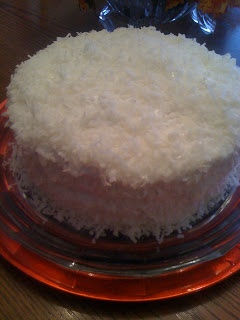 a cake with white frosting sitting on top of a glass plate