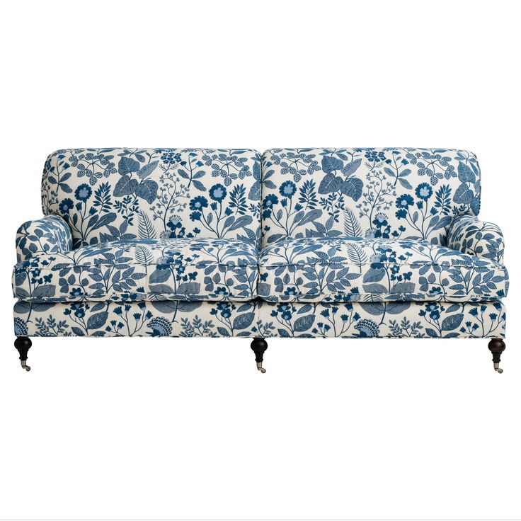 a blue and white floral couch with wooden legs