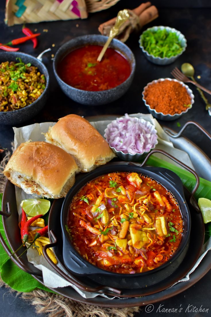 an assortment of food is displayed on a plate, including bread and chili sauces