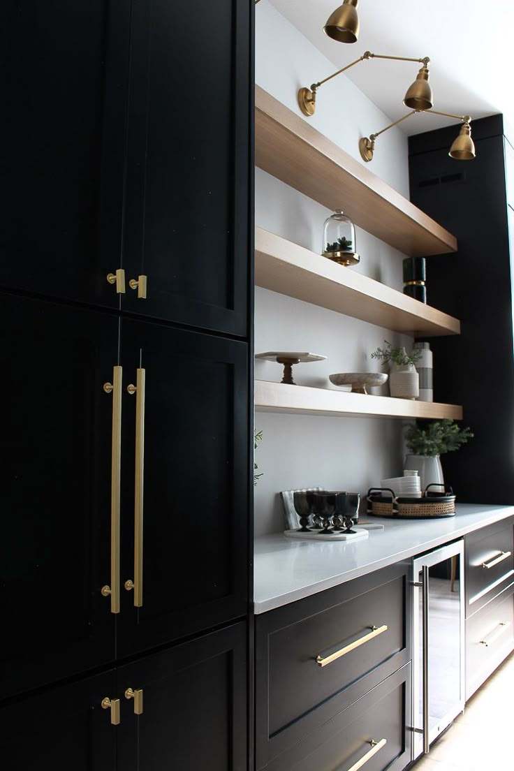 an instagram page with black cabinets and gold pulls on the doors, along with shelves