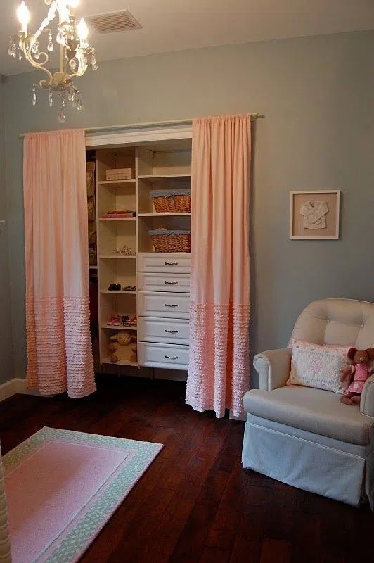 a baby's room with pink curtains and furniture