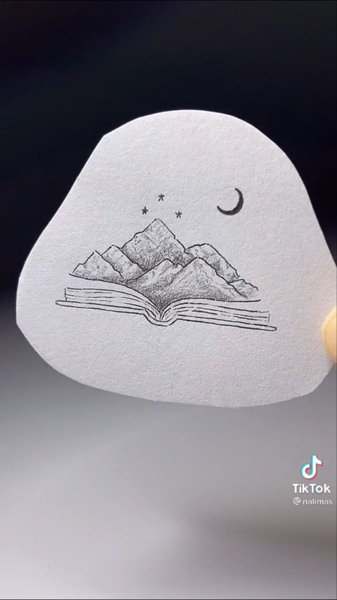 an open book with mountains in the background and a crescent on it's cover