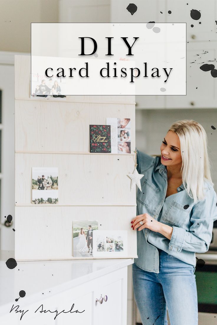 a woman standing next to a wall with pictures on it and the words diy card display