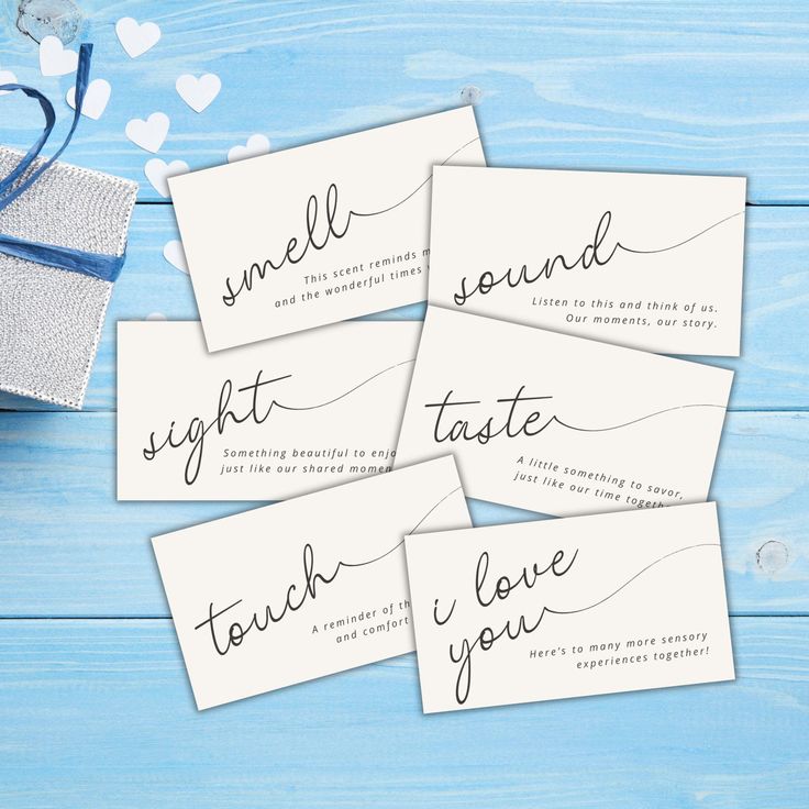 four cards with the words smell, sight, taste and love written on them next to a gift bag