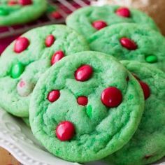 green cookies with red and green sprinkles on a white plate