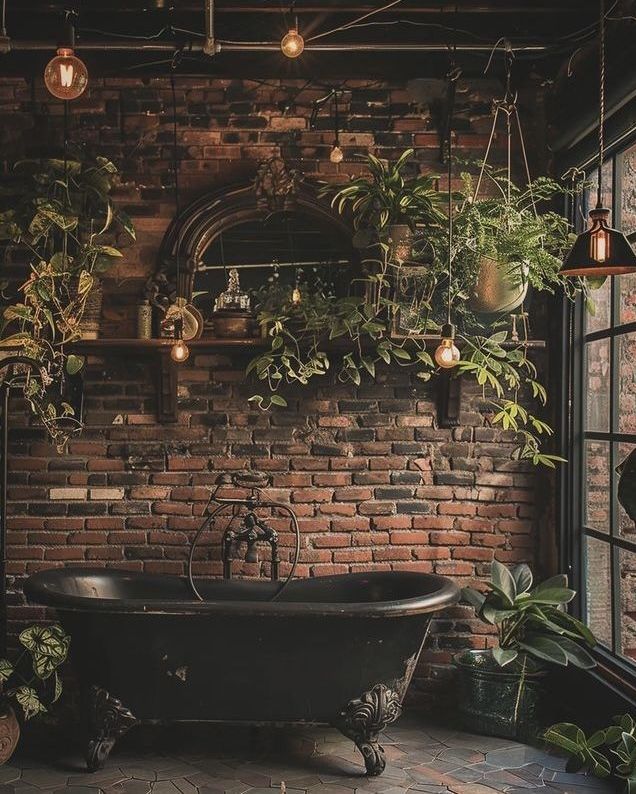 an old fashioned bathtub with plants hanging from the ceiling in front of a brick wall