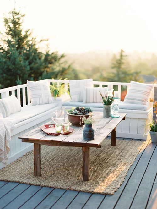 a white couch sitting on top of a wooden floor next to a table and chairs