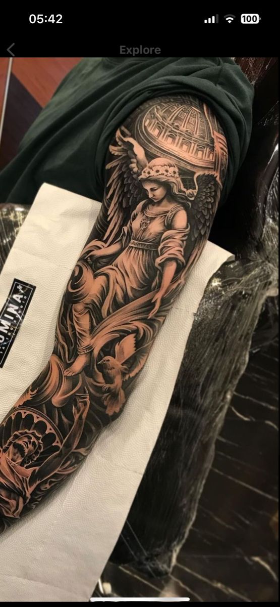 a man's arm with an angel tattoo on it