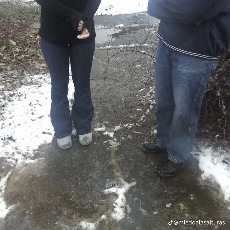 a man and woman standing in the snow