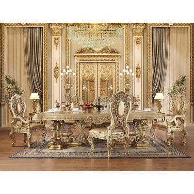 a fancy dining room with gold furniture and chandelier