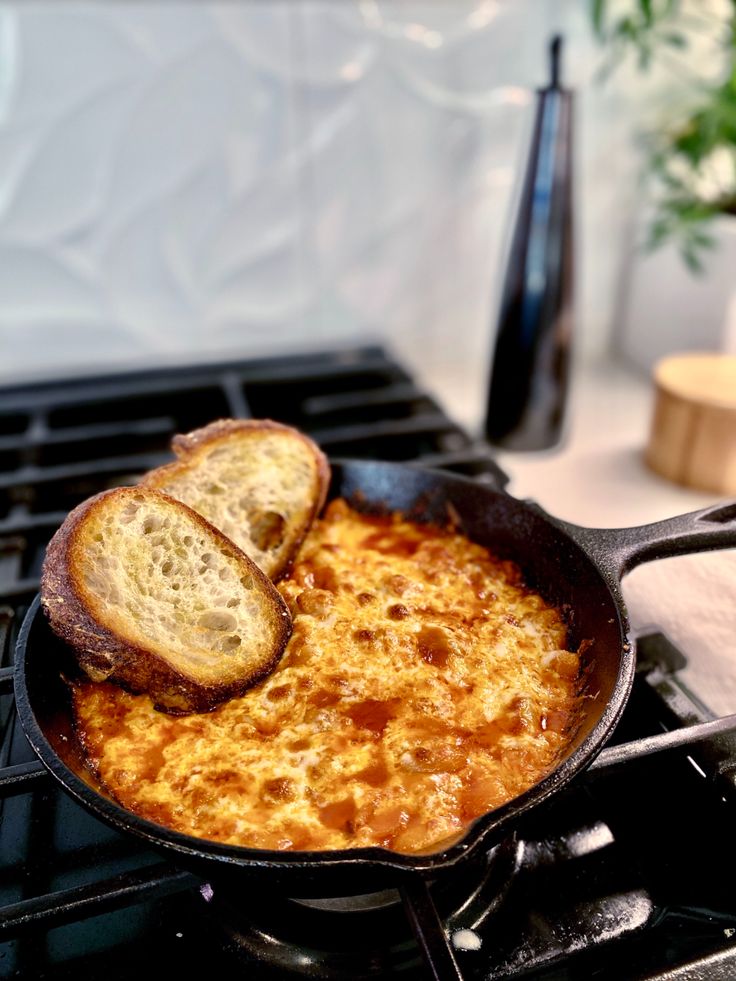 two pieces of bread are being cooked in a skillet on top of the stove