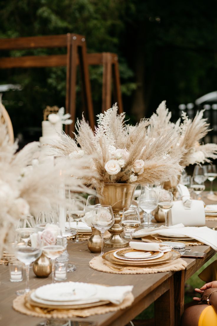 the table is set with white and gold place settings