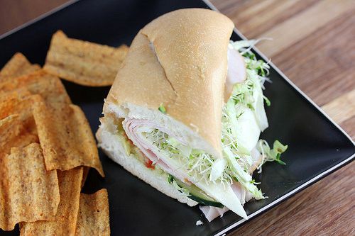 a sandwich and french fries on a black plate