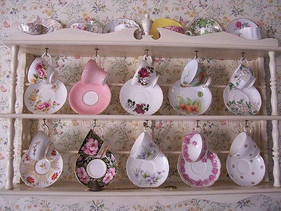 there are many tea cups and saucers on the shelf