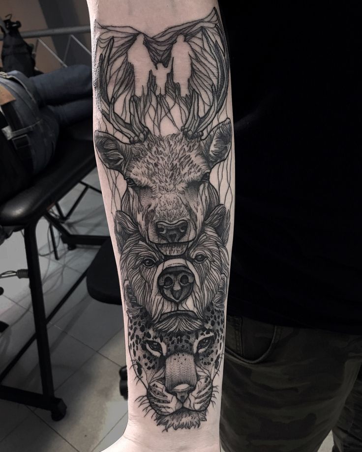 a man with a deer and wolf tattoo on his arm