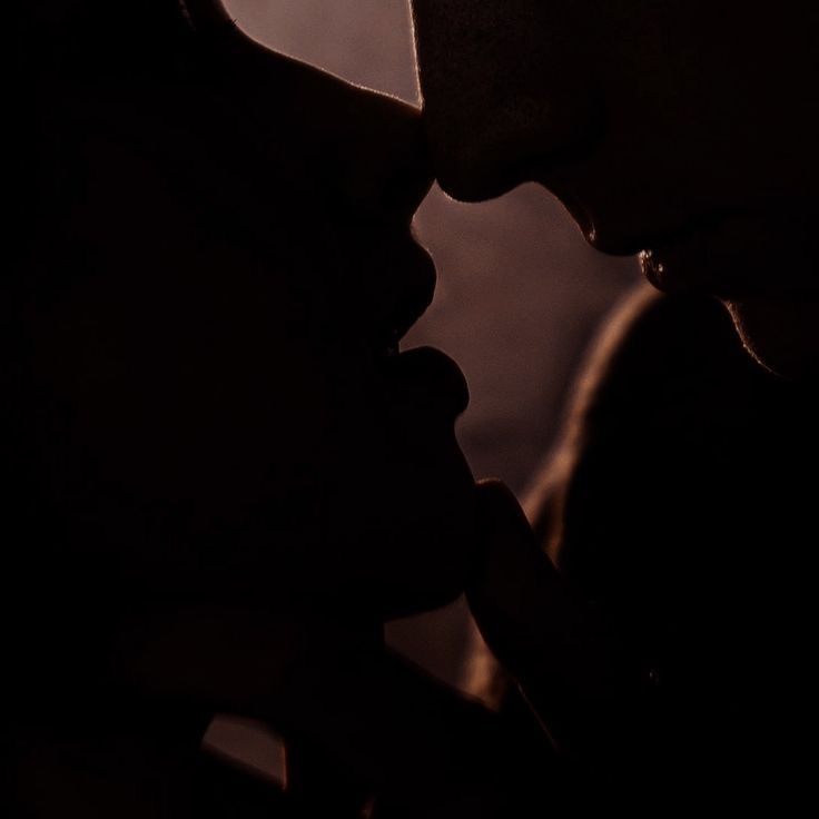 the silhouette of two people kissing each other